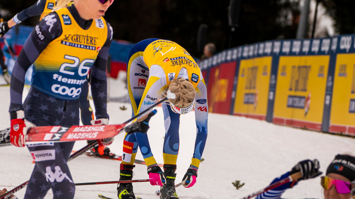 En helt utpumpad Frida Karlsson faller ner på marken efter målgång på den sista etappen av Tour de Ski förra året. Arkivbild.