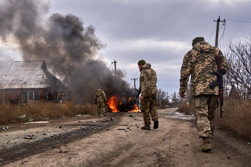 Ukrainska soldater passerar en brinnande buss som träffats av en rysk drönare nära Bakhmut i Donetskregionen.