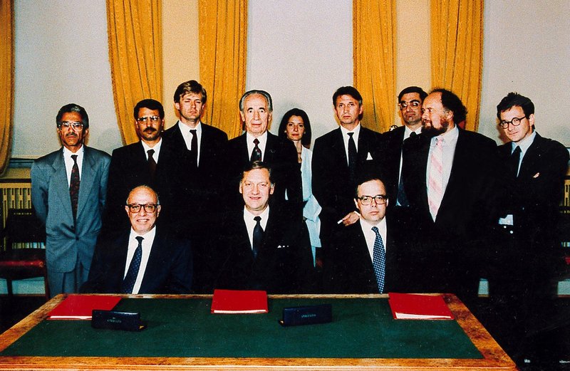 Huvudaktörerna bakom Osloavtalet 1993. I mitten vid bordet sitter Norges dåvarande utrikesminister Johan Jørgen Holst, flankerad till vänster av palestiniernas chefsförhandlare Ahmad Qorei och till höger av israelernas dito Uri Savir. Bakom Holst ses Israels dåvarande utrikesminister Shimon Peres.