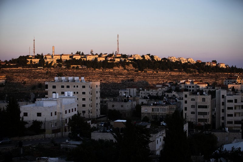 Bosättningen Psagot, beläget på en höjd, syns från stora delar av den palestinska byn al-Bireh. Bild från 2020.