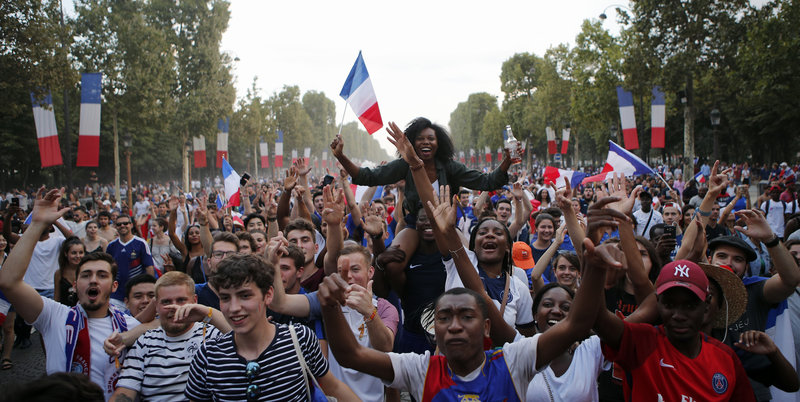 Folkhav vid Champs Élysée firar Frankrikes vinst med flaggor. 