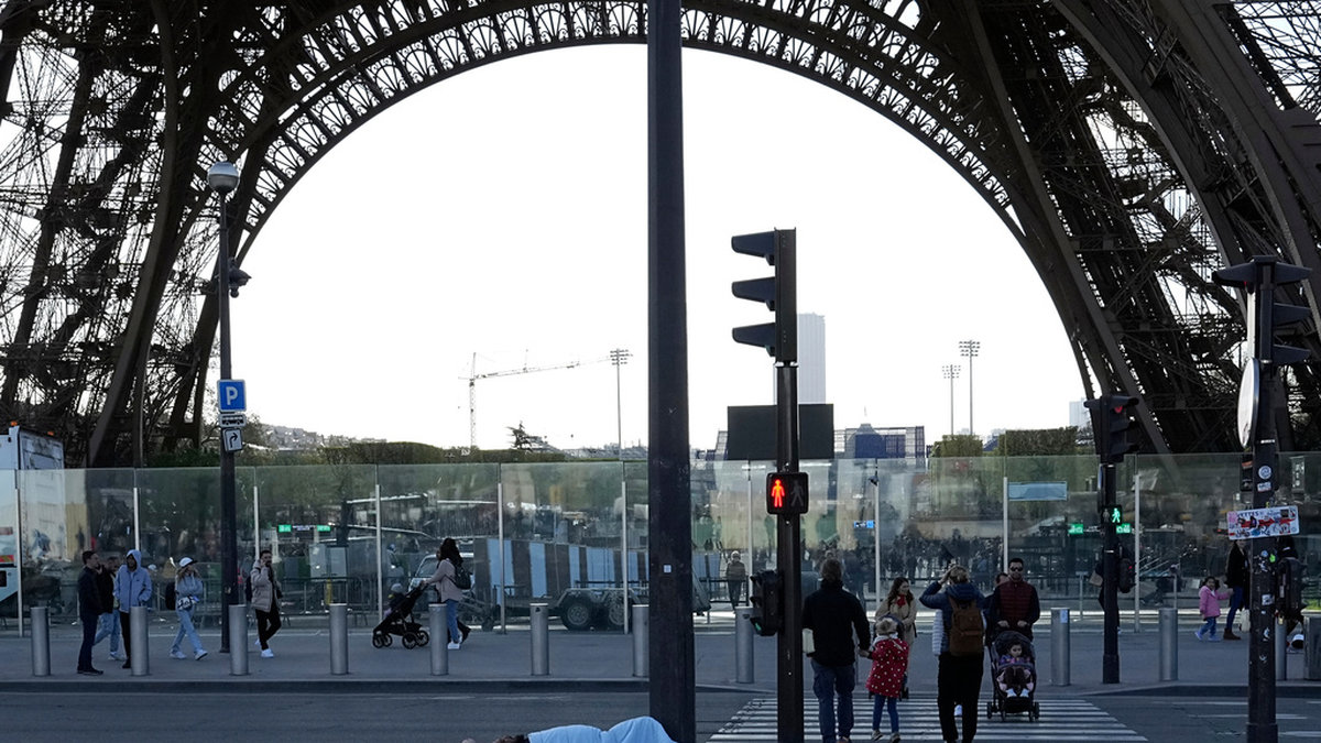 En hemlös person sover i närheten av Eiffeltornet i centrala Paris tidigare i april.