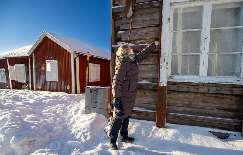 Anna Elmén Berg inspekterar en av stuga där fasaden måste renoveras.