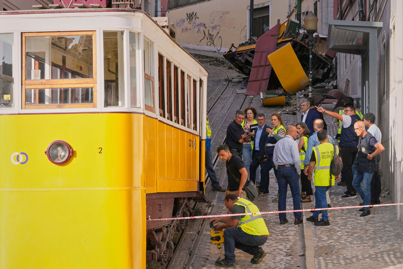 Utredare arbetar vid olycksplatsen. Den kraschade vagnen syns längst bort i bilden.