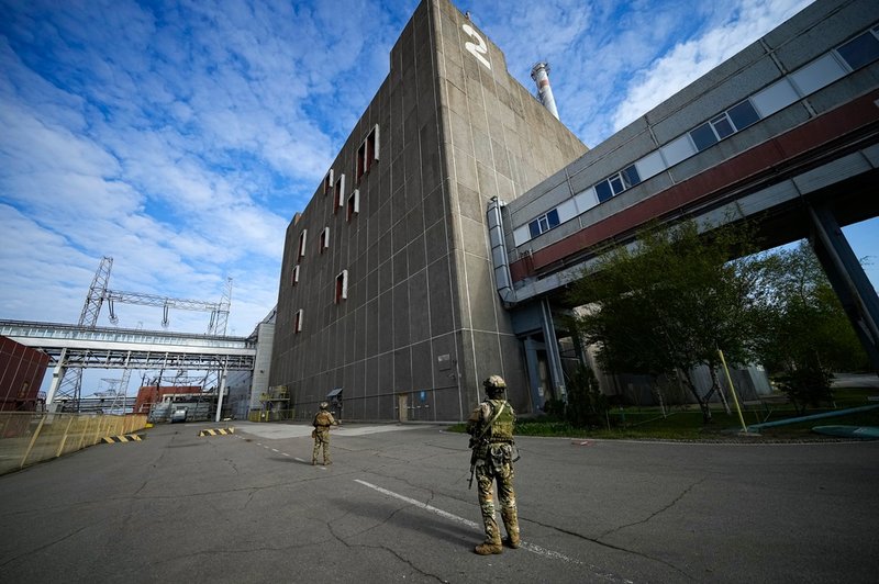 Ryska soldater står vakt utanför det ockuperade kärnkraftverket i Zaporizjzja, den 1 maj i år. Arkivbild.