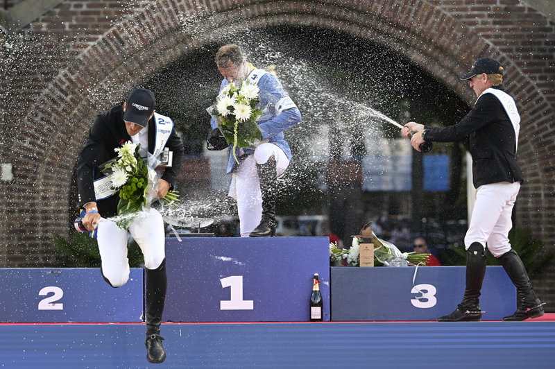 Henrik von Eckermann flyr prispallen där Christian Ahlman får en skur skumpa sprutat på sig av trean Marcus Ehning.