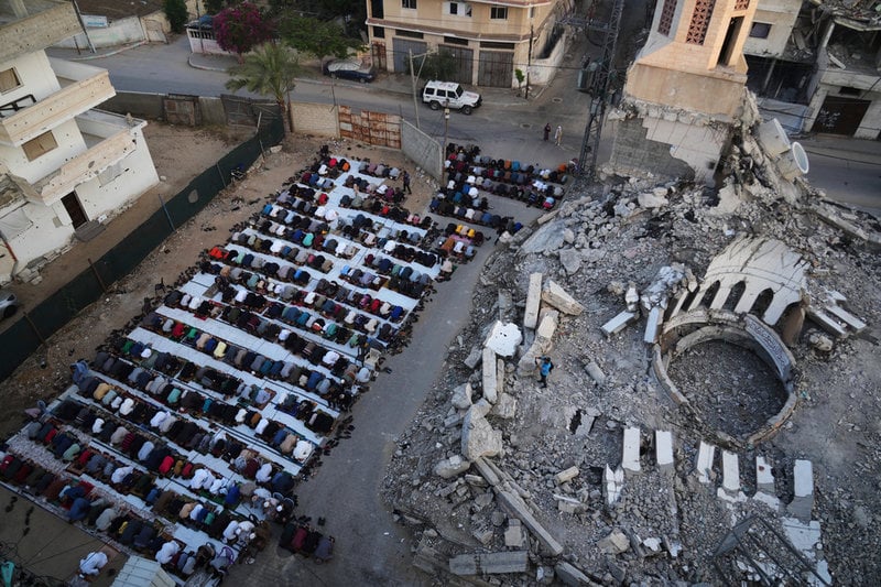 Palestinier samlade till bön invid ruinerna av en moské i Dayr al-Balah.
