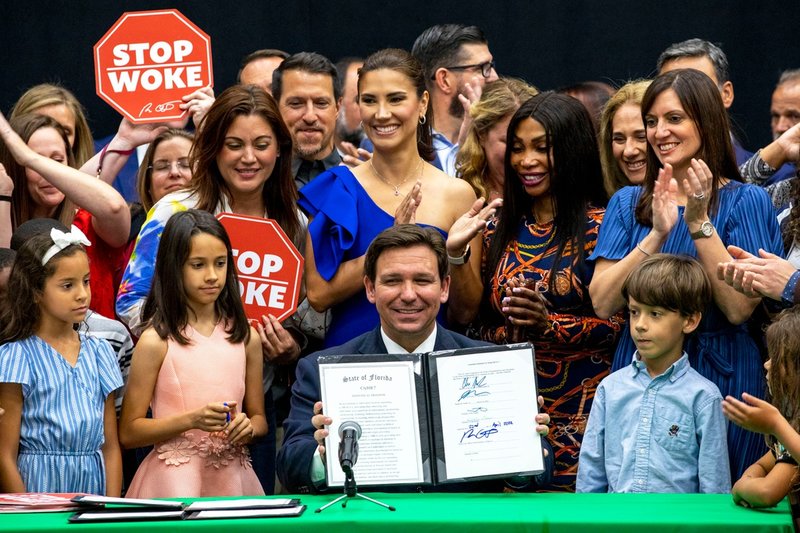 Ron DeSantis visar upp sin signatur på sin 'stop woke'-lag, som begränsar diskussioner om ras och etnicitet, i april. Delar av lagen har rivits upp av en federal domare i Florida med hänvisning till att den strider mot grundlagen.