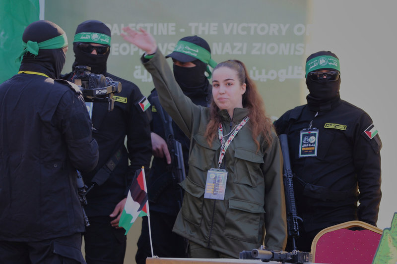 Omgiven av milismän från Islamiska jihad vinkar Agam Berger i samband med frisläppandet i Jabalia, nära Gaza stad.