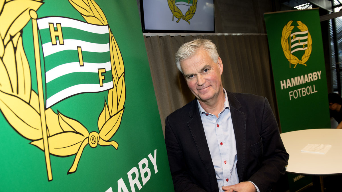 Nanne Bergstrand poserar vid det klubbmärke som han nu kommer att representera i de fyra kommande åren.