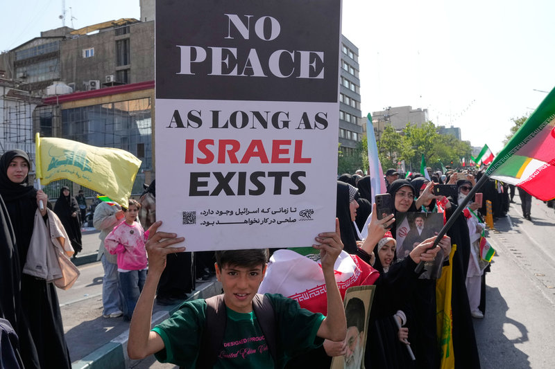 ”Ingen fred så länge Israel existerar”. En pojke med en skylt vid en statligt organiserad demonstration i Teheran på fredagen.