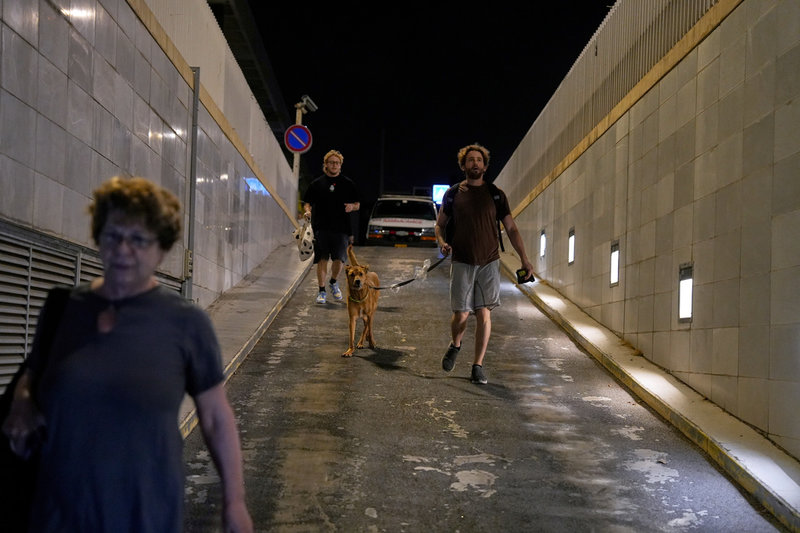 Israeler tar skydd i ett parkeringsgarage när flyglarmet ljuder i Tel Aviv tidigt på tisdagen.