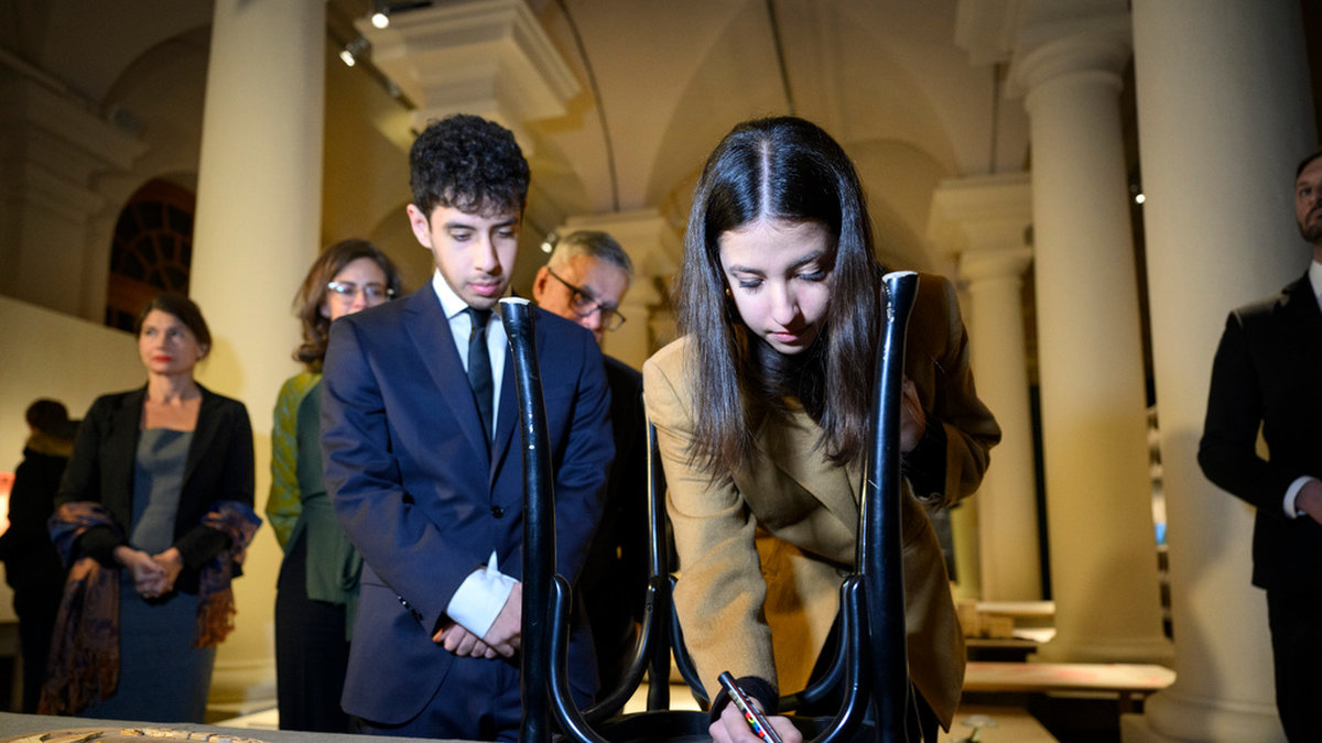Narges Mohammadi, som sitter fängslad i Iran, representerades av sina två barn, 17-åriga Ali och Kiana Rahmani på Nobelprismuseet i onsdags. De besökte Stockholm tillsammans med sin pappa Taghi Rahmani, make till Narges Mohammadi, och signerade en stol samt överlämnade ett flertal föremål till museet.