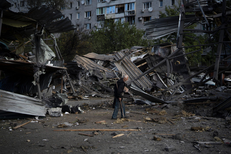 En äldre man går förbi en butik som förstörts i en rysk attack mot Zaporizjzja den 11 oktober.