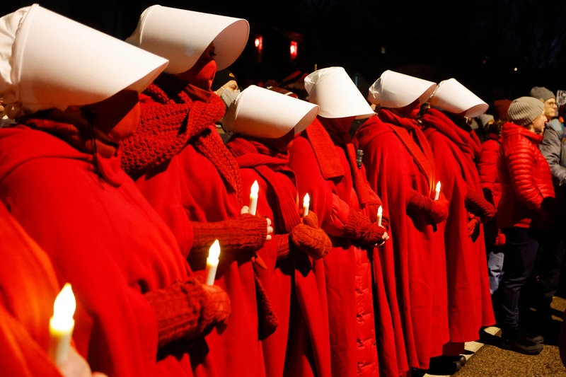 Människor klädda som i tv-serien "The Handmaid's Tale", som bygger på Margaret Atwoods klassiska dystopi om ett framtida totalitärt USA, under en minnesstund för den dödade kvinnan.