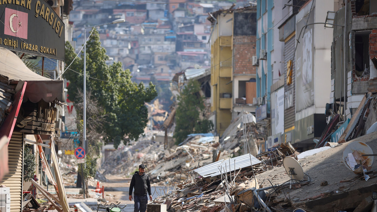 En man bland förstörda byggnader i den turkiska staden Antakya.