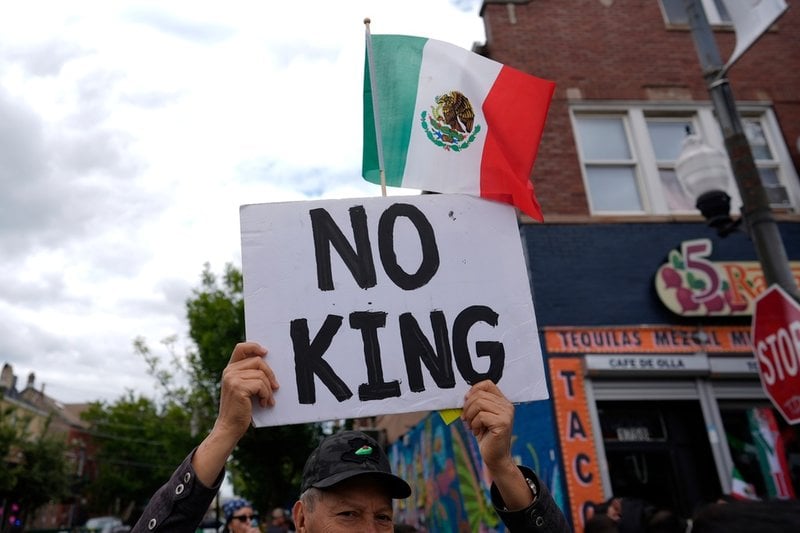 En man i Chicago håller upp en anti-Trump skylt under en mexikansk parad i Chicago på lördagen.