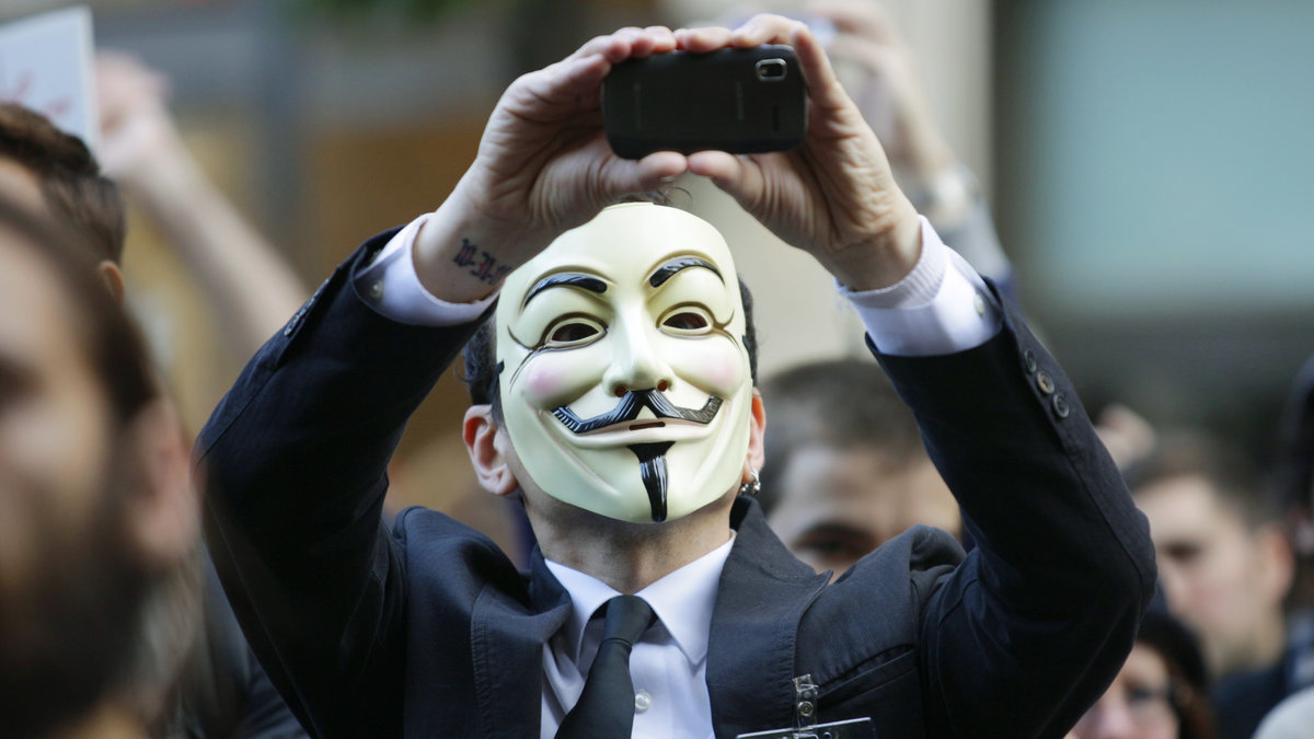 En person med den med Anonymous förknippade Guy Fawkes-masken.