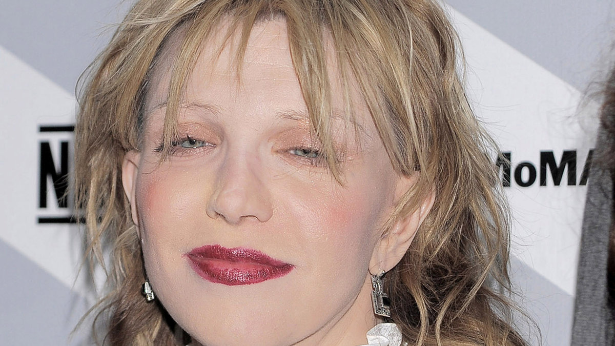 Courtney Love med blödande läppstift, genomskinlig hud, bortplockade ögonbryn och två rosa bollar på kinderna. Varför? 