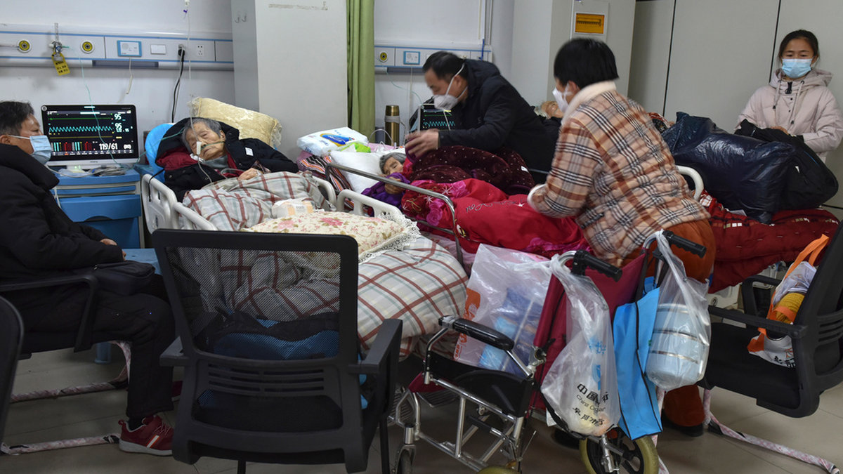 Familjemedlemmar sköter om äldre släktingar med covidsymtom på ett sjukhus i Fuyang i provinsen Anhui.