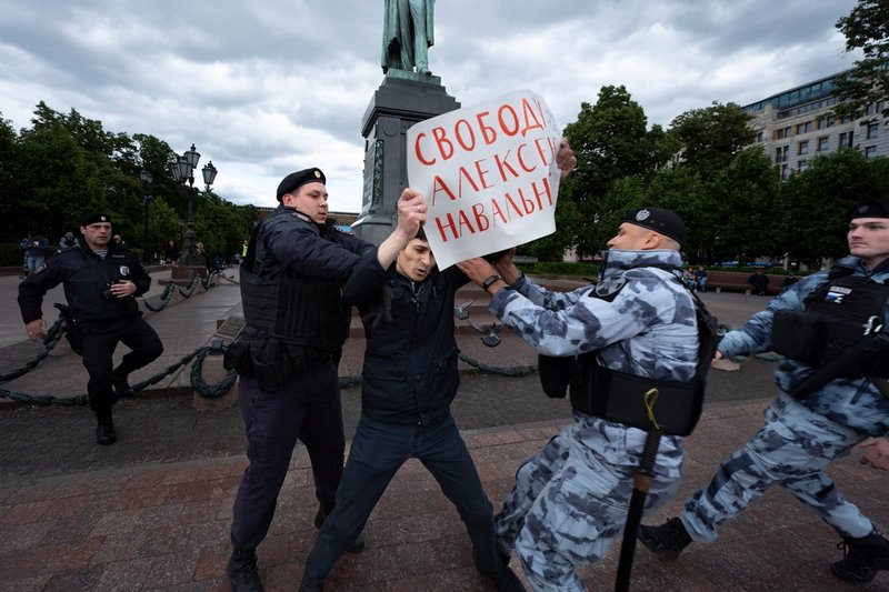 Demonstranter ställde sig på Pusjkintorget i Moskva i juni i år med ett plakat där de skrivit 'Frihet för Aleksej Navalnyj'. Här ingriper polisen. Arkivbild.