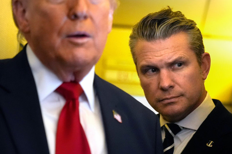 Pete Hegseth bakom sin chef Donald Trump ombord på presidentplanet Air Force One tidigare i mars.