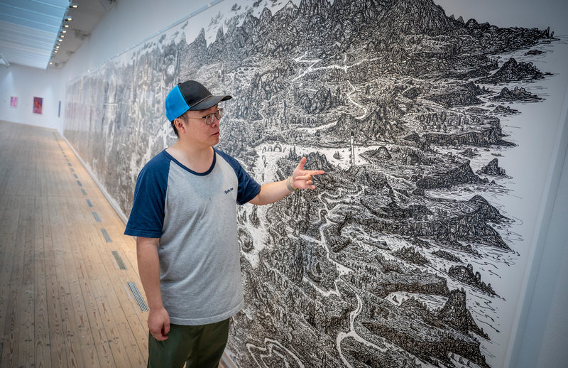 Konstnären David Cheung framför sitt 20 meter långa verk i utställningen "Speaking volumes", som visas på Malmö konsthall mellan den 13 september och den 18 januari nästa år.