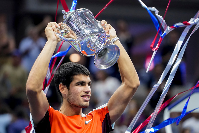 Carlos Alcaraz håller upp mästerskapsbucklan.