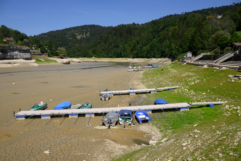 Strandade båtar i sjön Lac Brenet i västra Schweiz i mitten av juli. Vattennivån har sjunkit kraftigt i flera av landets mest kända sjöar.