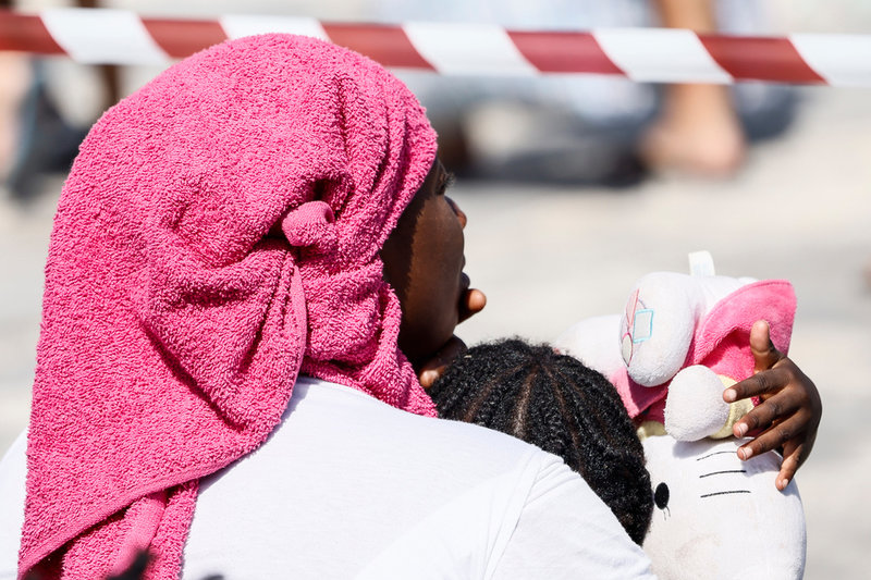 Stora och små migranter väntar på transport från ön Lampedusa till det italienska fastlandet, där de flesta hoppas kunna söka asyl.