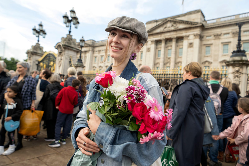 Veve från Tyskland lägger blommor utanför Buckingham Palace i London med anledning av drottning Elizabeths bortgång.