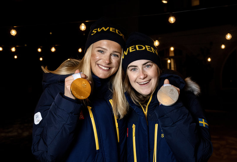 Sveriges Frida Karlsson med sin guldmedalj och Ebba Andersson med sin silvermedalj från damernas skiathlon 10+10 km under vinter-OS i Val di Femme i Italien. Foto: Christine Olsson / TT