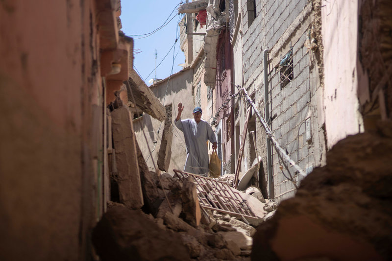 En man försöker ta sig fram bland raserade hus i byn Amizmiz nära Marrakech.