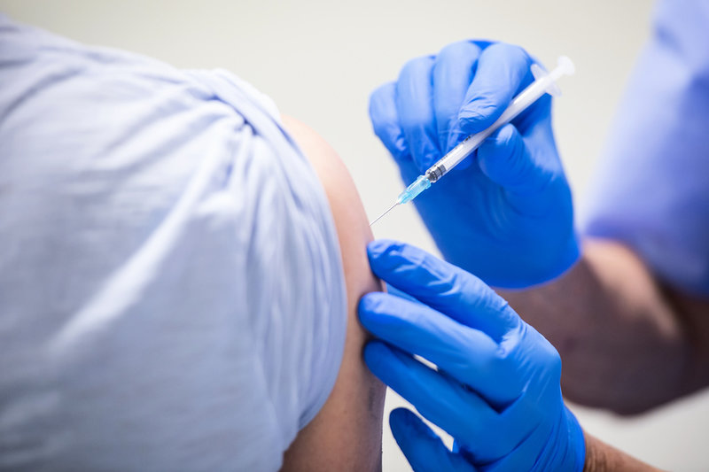 En vaccinatör ger en man en dos covidvaccin. Arkivbild.