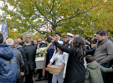  Några på begravningen håller upp bilder på Lavin Eskandar enligt P4 Väst.