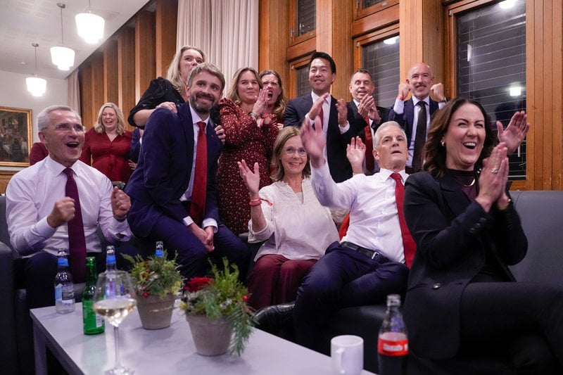 Finansminister Jens Stoltenberg (vänster) och statsminister Jonas Gahr Støre (sittande näst längst till höger) tar emot NTB:s prognos vid Arbeiderpartiets valvaka på Folkets hus i Oslo.
