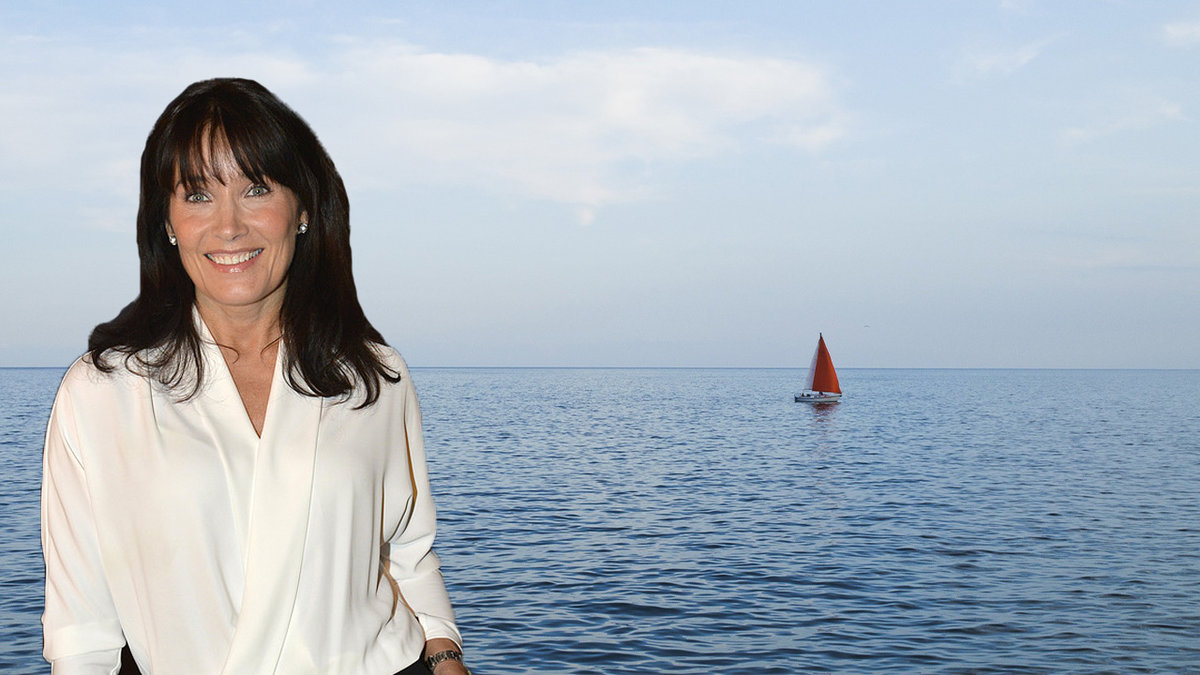 en kvinna i brunt hårt och vit topp, blått hav med en segelbåt