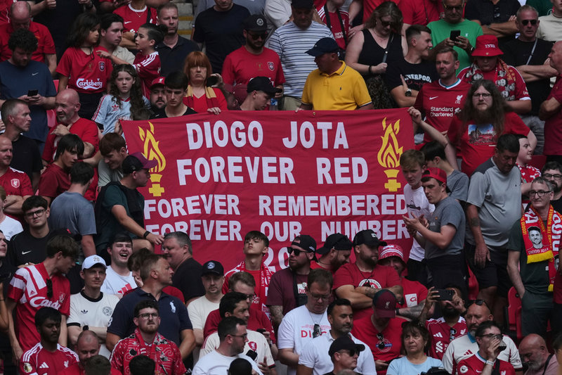 Liverpool-supportrar med en banderoll som hyllar Diogo Jota.