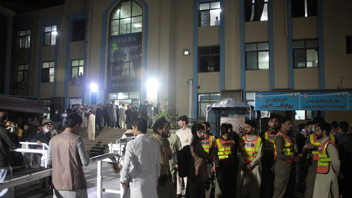 Räddningsarbetare och andra människor samlas utanför ett sjukhus i Pakistan.