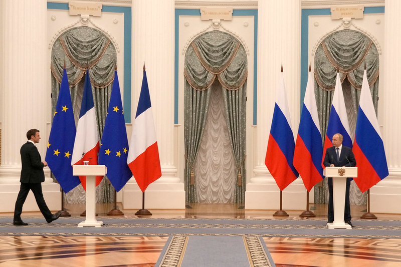Emmanuel Macron kliver fram till sin plats på presskonferensen tillsammans med Vladimir Putin.