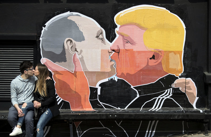 Ett par kysser varandra framför en graffitimålning föreställande Vladimir Putin och Donald Trump i Litauens huvudstad Vilnius 2016.