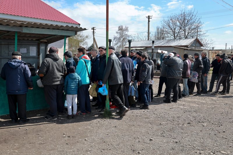 Människor köar för mat i byn Bezimenne i Donetskregionen i östra Ukraina.