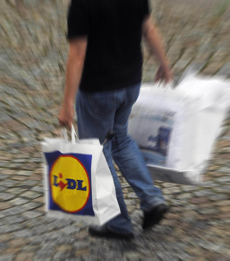 Person bär kassar från Lidl Person bär kassar från Lidl