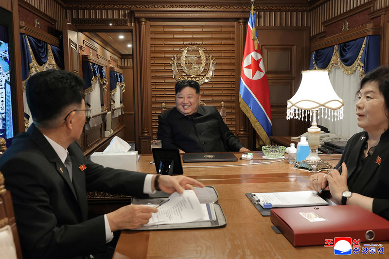 Kim Jong-Un, i mitten, på tåget på väg till Peking, enligt de regimtrogna nordkoreanska medier som distribuerat bilden på tisdagen.