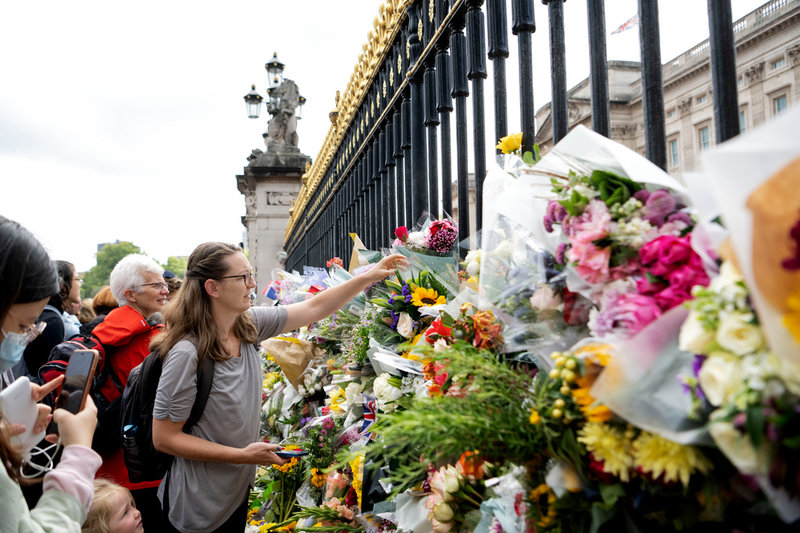 Människor lägger blommor utanför Buckingham Palace i London.