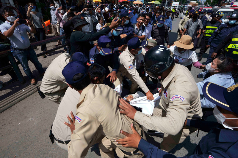 Demonstranter frihetsberövas utanför domstolen i Phnom Penh, där medlemmar ur numer upplösta oppositionspartiet CNRP dömdes den 14 juni.