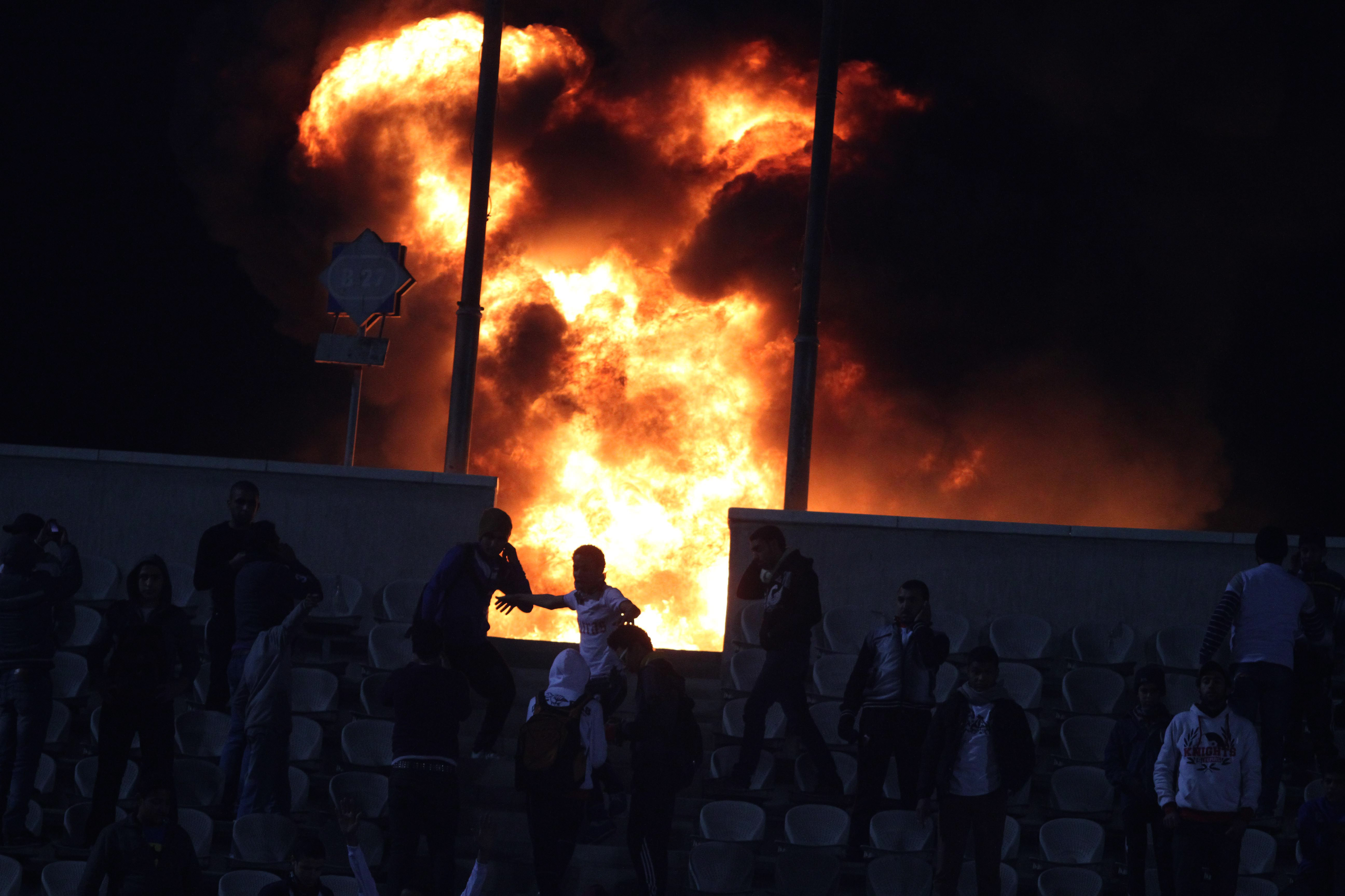 Supportrar satte eld på läktarna efter att matchen avbrutits. Flera klämdes ihjäl på Al-Ahly-sektionen som inte fick utrymmas.
