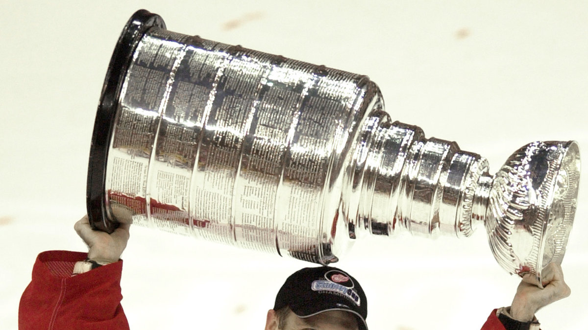 Dominik Hasek lyfter sin första Stanley Cup-buckla 2002.