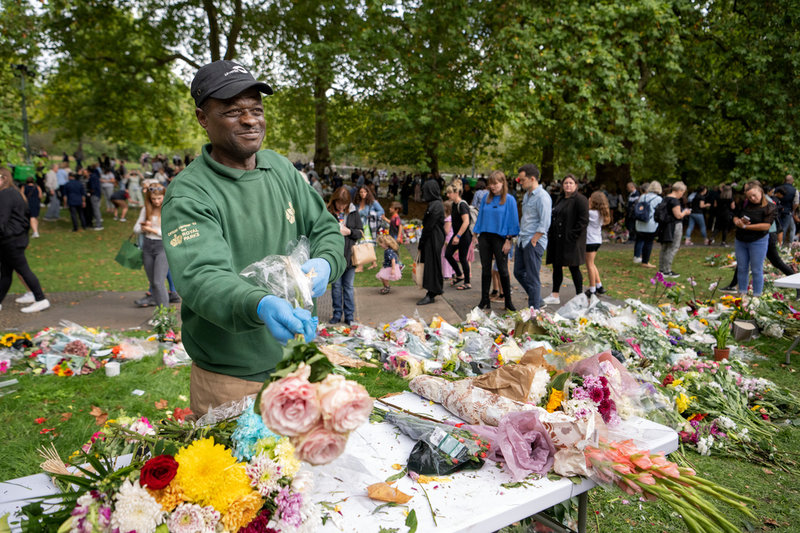 Bob Cole tar bort plasten från alla de blommor som lämnats vid Buckingham Palace.