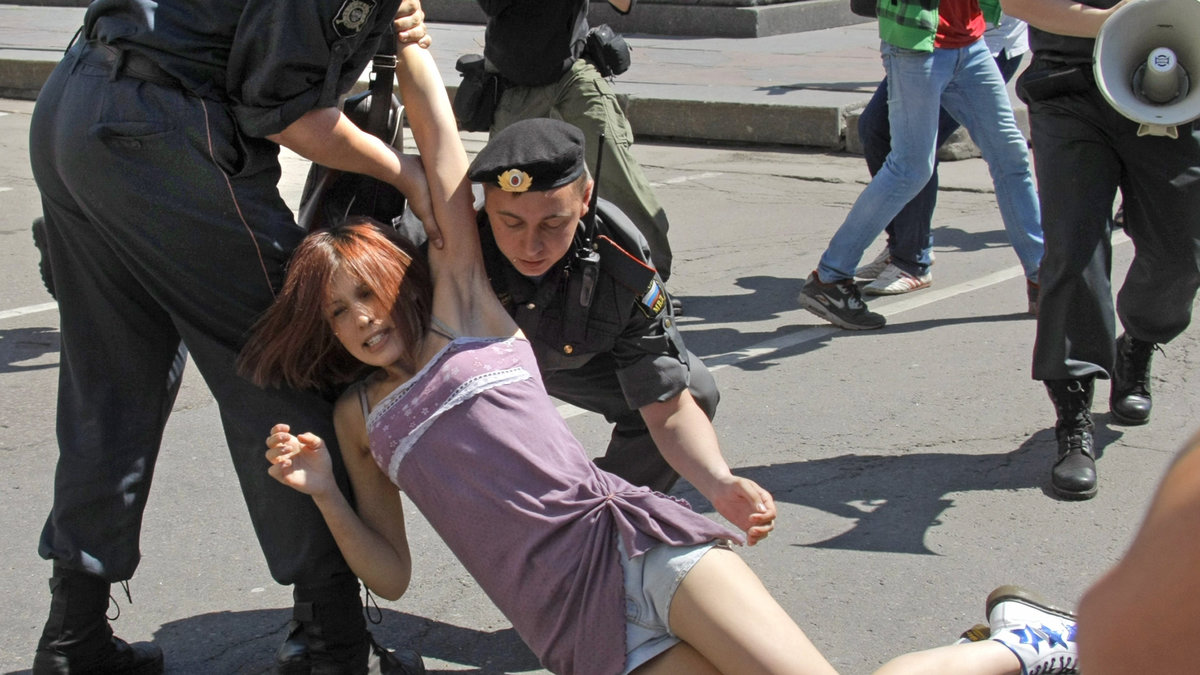 En kvinna grips under en manifestation.
